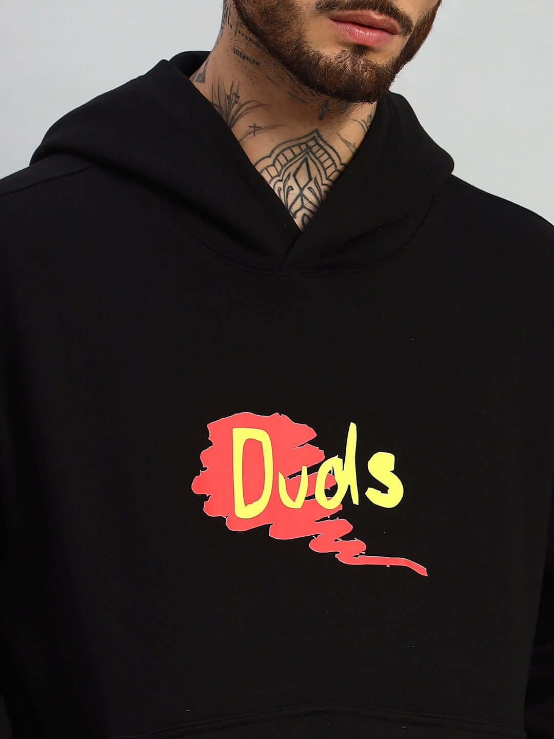 Close-up of a BLACK oversized hoodie featuring a colorful 'Duds' graphic on the chest, highlighting trendy streetwear style.