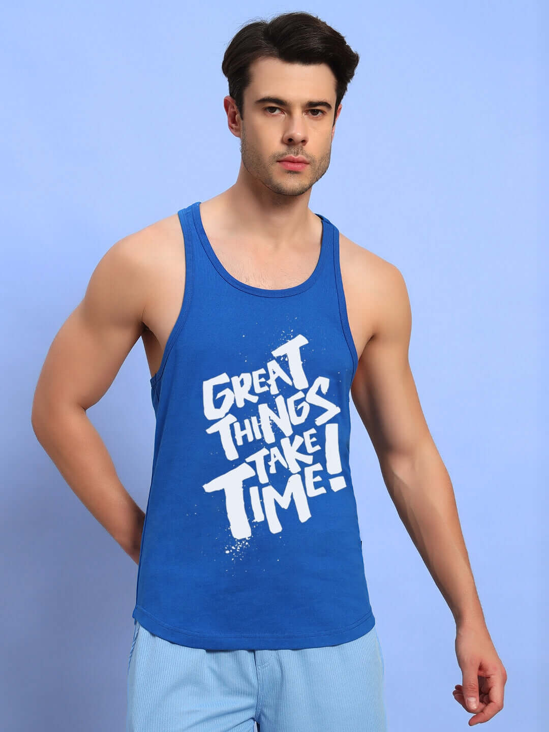 Alt Tag: Man wearing GREAT THINGS GYM T-SHIRT ROYAL BLUE with text 'Great Things Take Time' on a blue background.