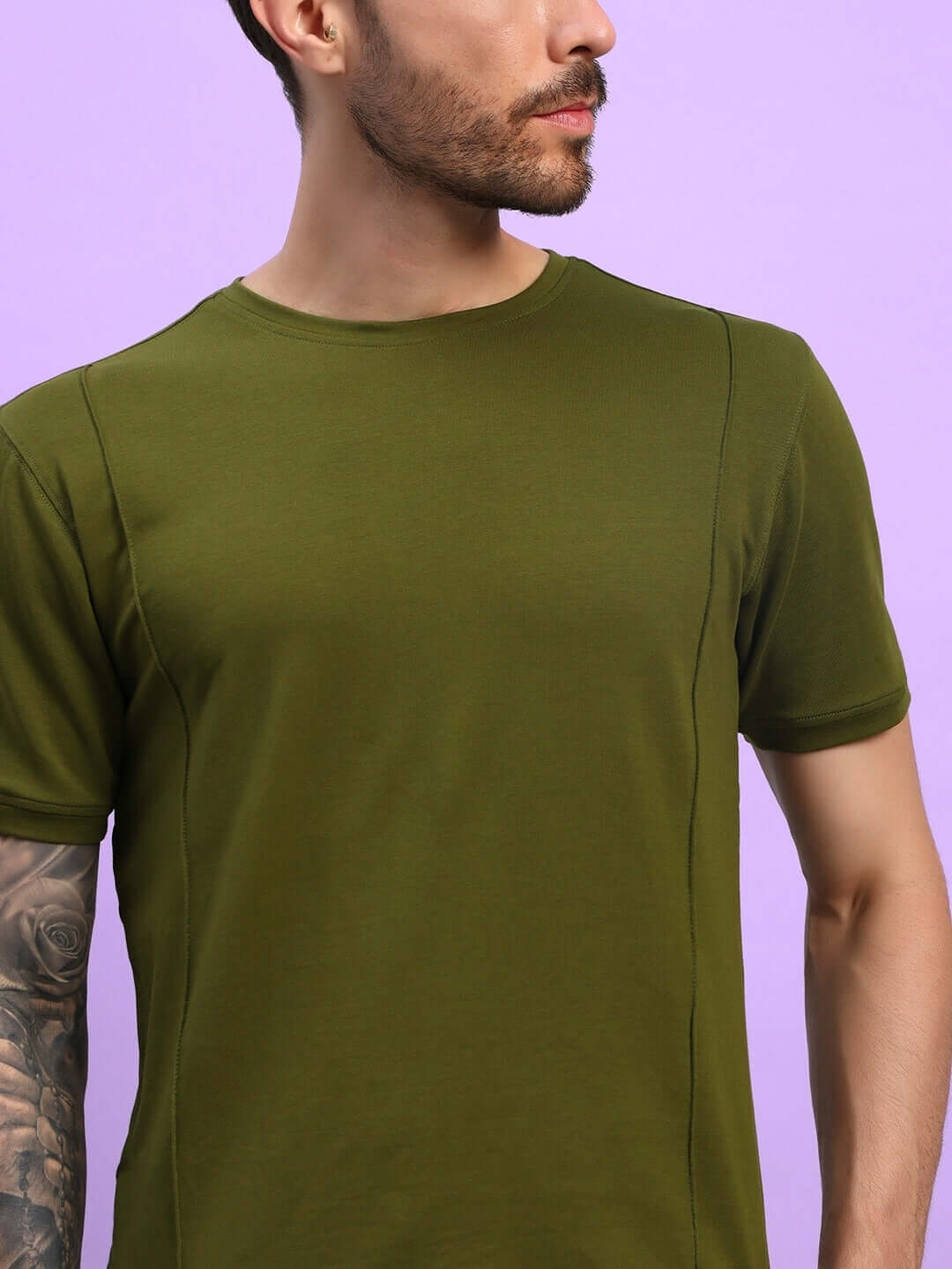 Man wearing Greeble Co-Ord Set in olive green, made from premium cotton French terry lycra, showcased against a purple background.