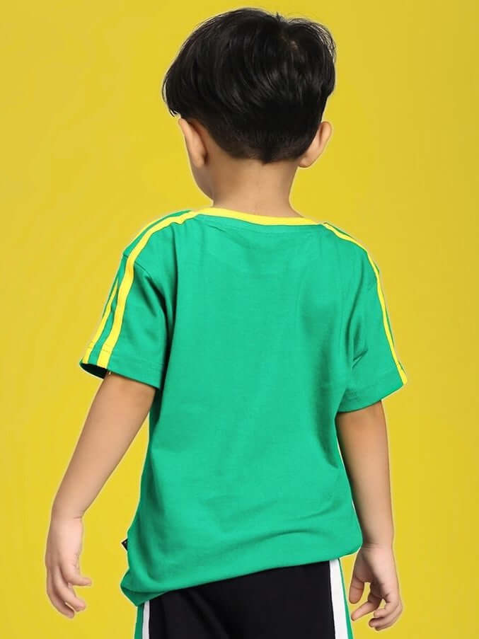 Back view of child wearing IRISH T-SHIRT FOR BOYS AND GIRLS GREEN with yellow stripes, standing against yellow background.