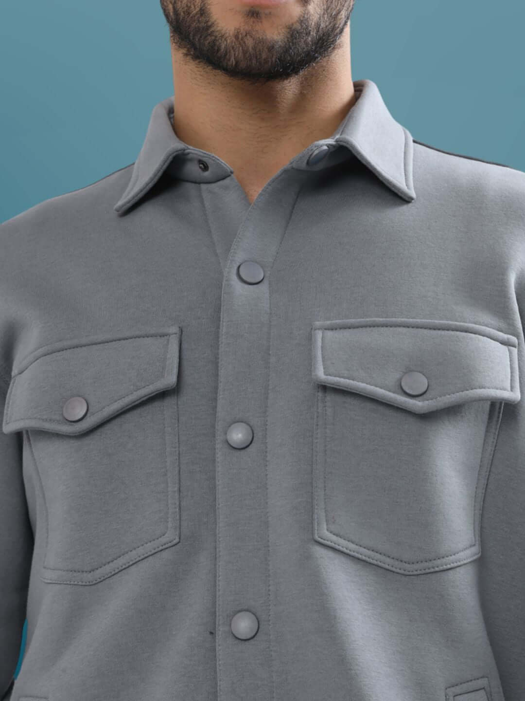 Close-up of a grey relaxed fit overshirt with buttoned pockets, ideal for custom size options.