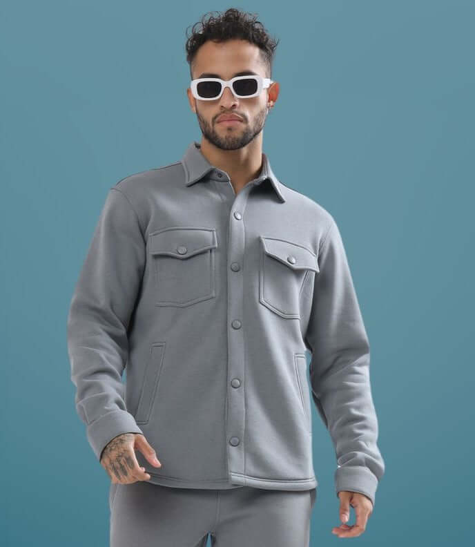 Grey relaxed fit overshirt worn by model with sunglasses, showcasing stylish and casual design.