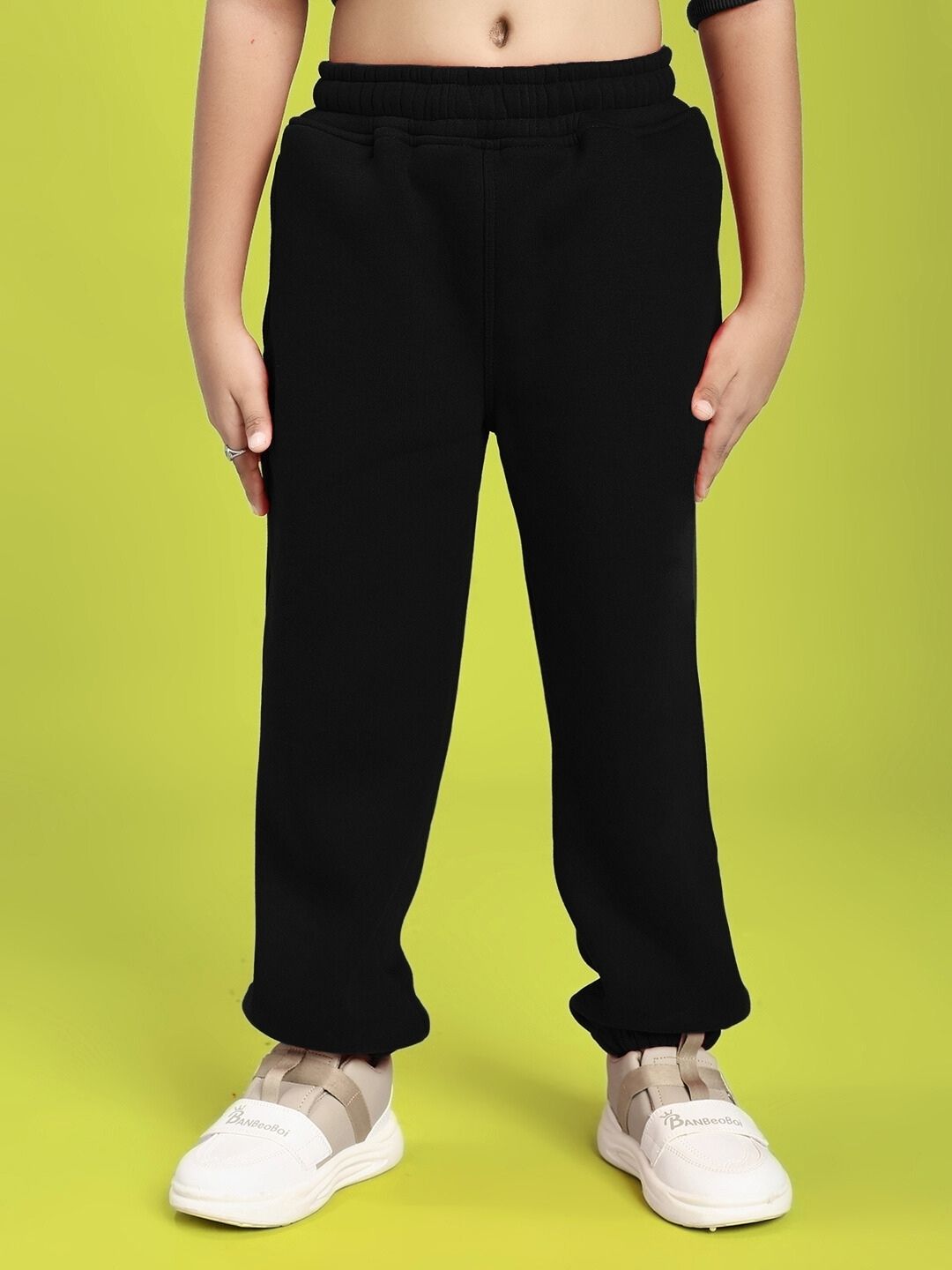 GROW AND GLOW FLEECE JOGGER FOR BOYS AND GIRLS BLACK, featuring a child wearing black fleece joggers against a green background.