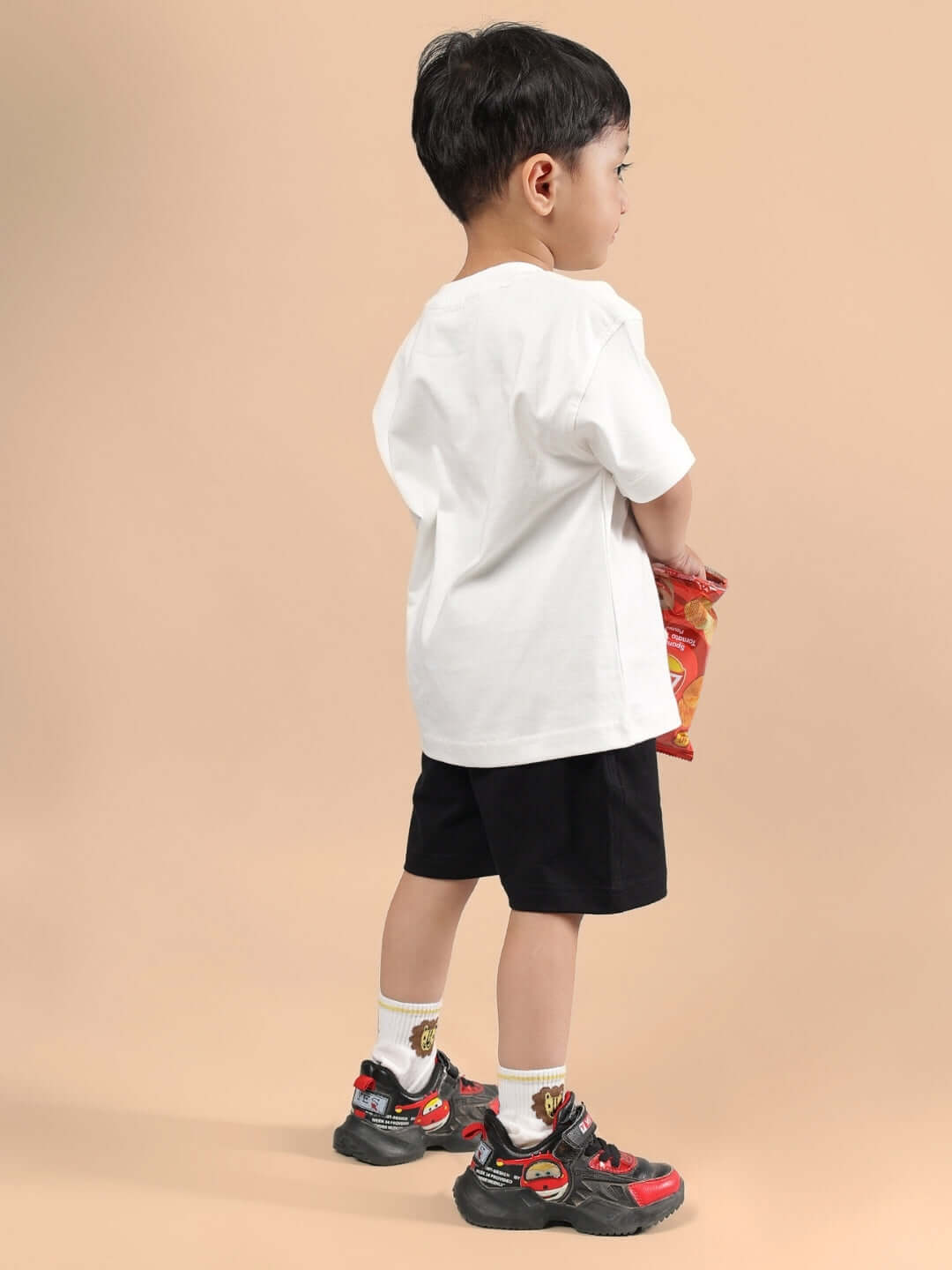 Child wearing HAKUNA MATATA CO-ORD FOR BOYS & GIRLS OFF WHITE-BLACK, showcasing a trendy outfit with off-white tee and black shorts