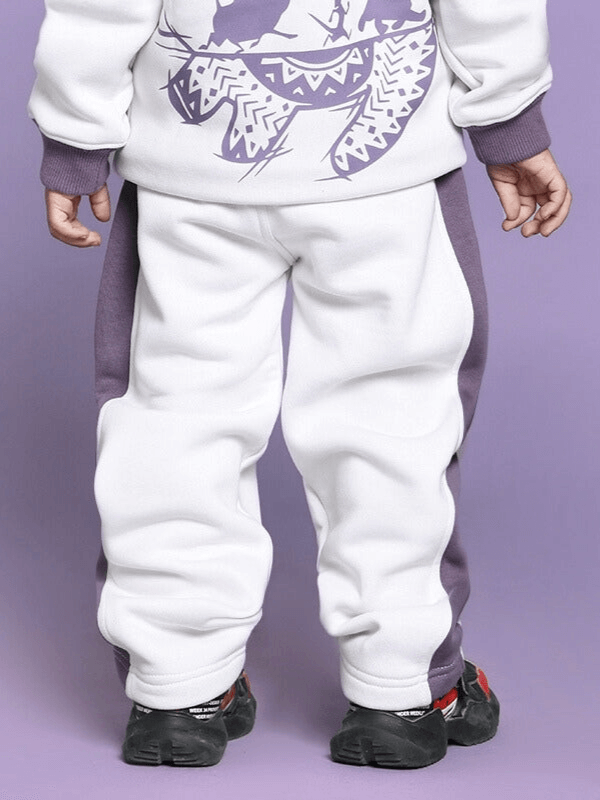 Child wearing Hakuna Matata white-violet fleece pants, rear view, showcasing unisex design for boys and girls.