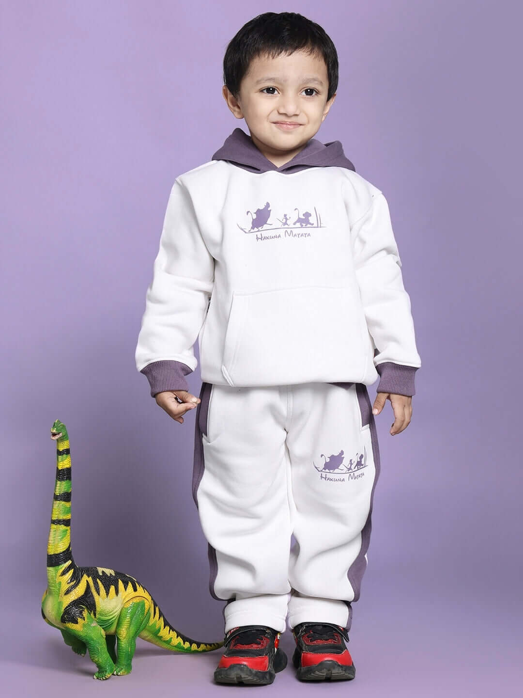 Child wearing Hakuna Matata oversized white and violet hoodie with dinosaur toy on the side.