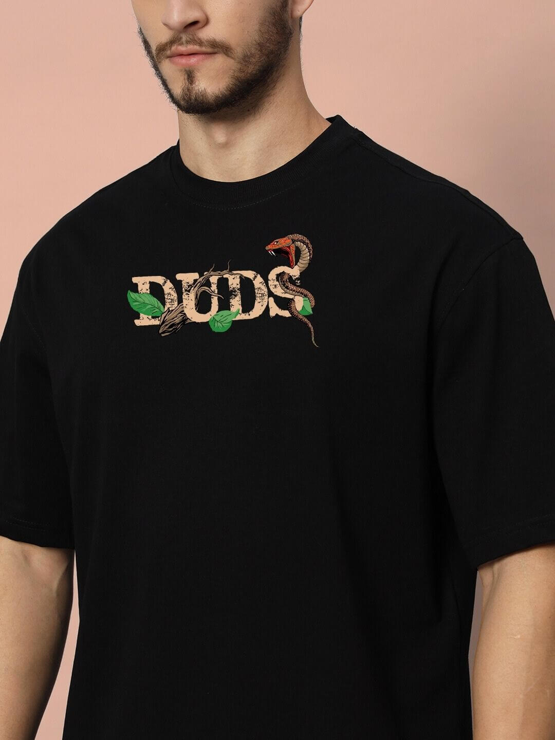Model wearing HAND SNAKE APPLE OVERSIZED T-SHIRT BLACK with symbolic graphic design for bold fashion statement.