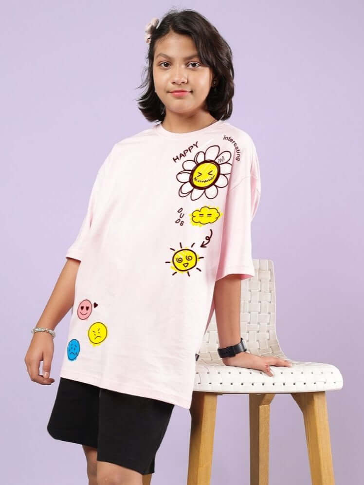 HAPPY INTERESTING OVERSIZED T-SHIRT FOR BOYS AND GIRLS PINK with cheerful prints modeled by a child, ideal for casual outings.
