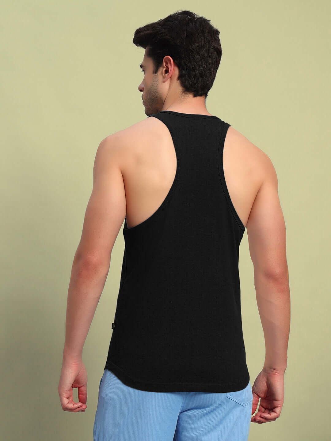 Man wearing HARDER GYM SLEEVLESS T-SHIRT BLACK from the back view, showcasing the comfortable fit and design.