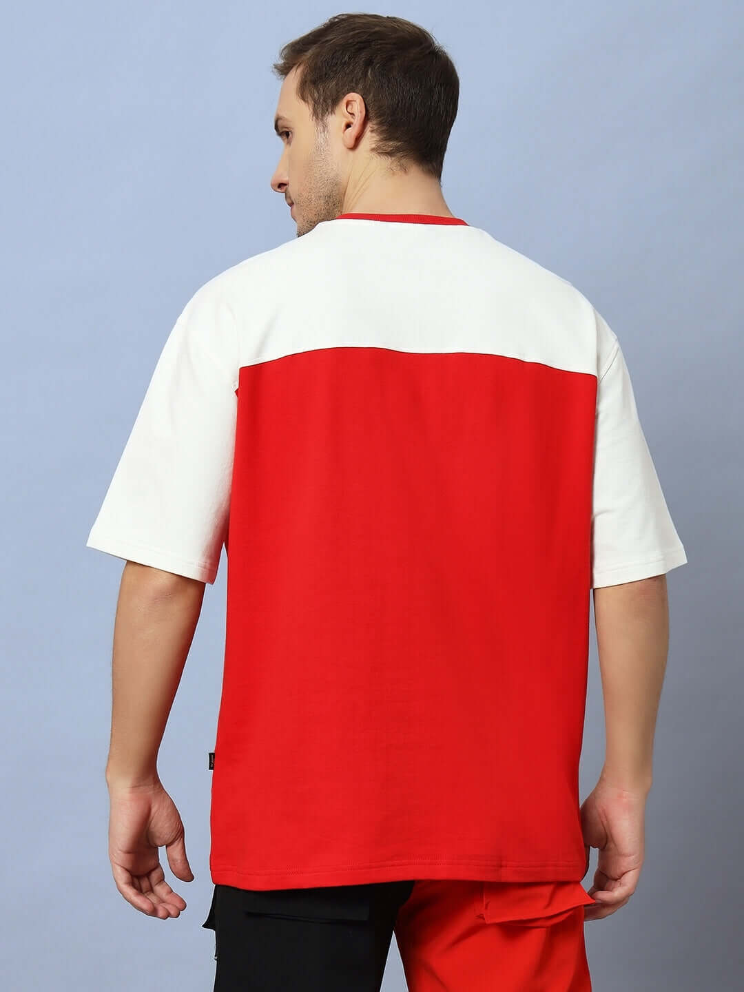 Back view of Harlem oversized off white-red t-shirt made from 97% premium cotton, ideal for casual wear, model wearing against a blue background.