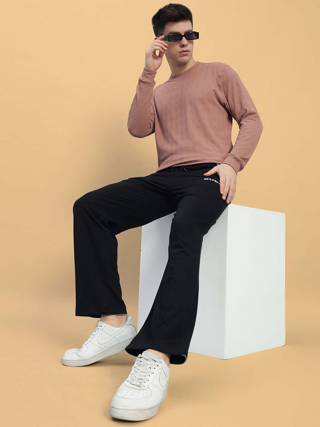 Model wearing HARPER Relaxed Fit Jogger in black, styled with a brown top and white sneakers, highlighting comfort and casual style.