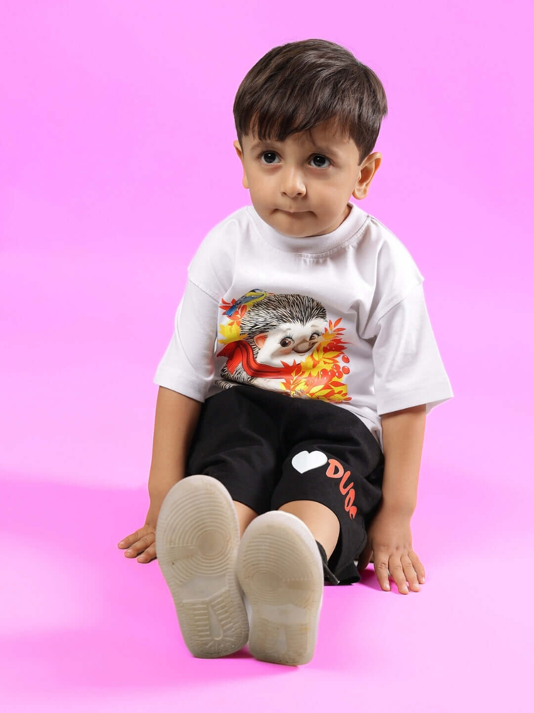 Child wearing HEDGEHOG CO-ORD FOR BOYS & GIRLS WHITE-BLACK outfit on pink background.