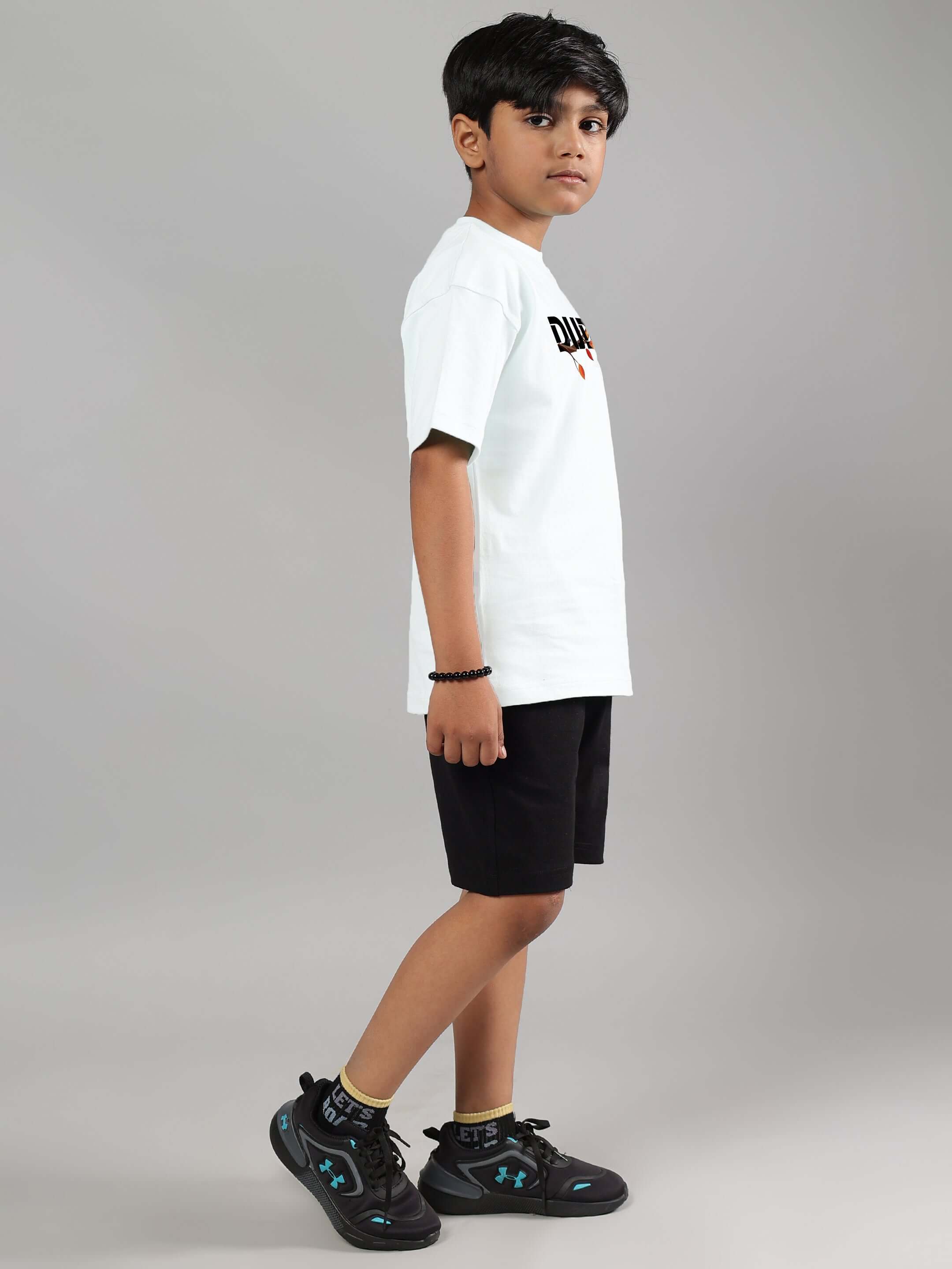 Boy wearing white and black Hedwig Co-ord by DUDS, standing sideways.