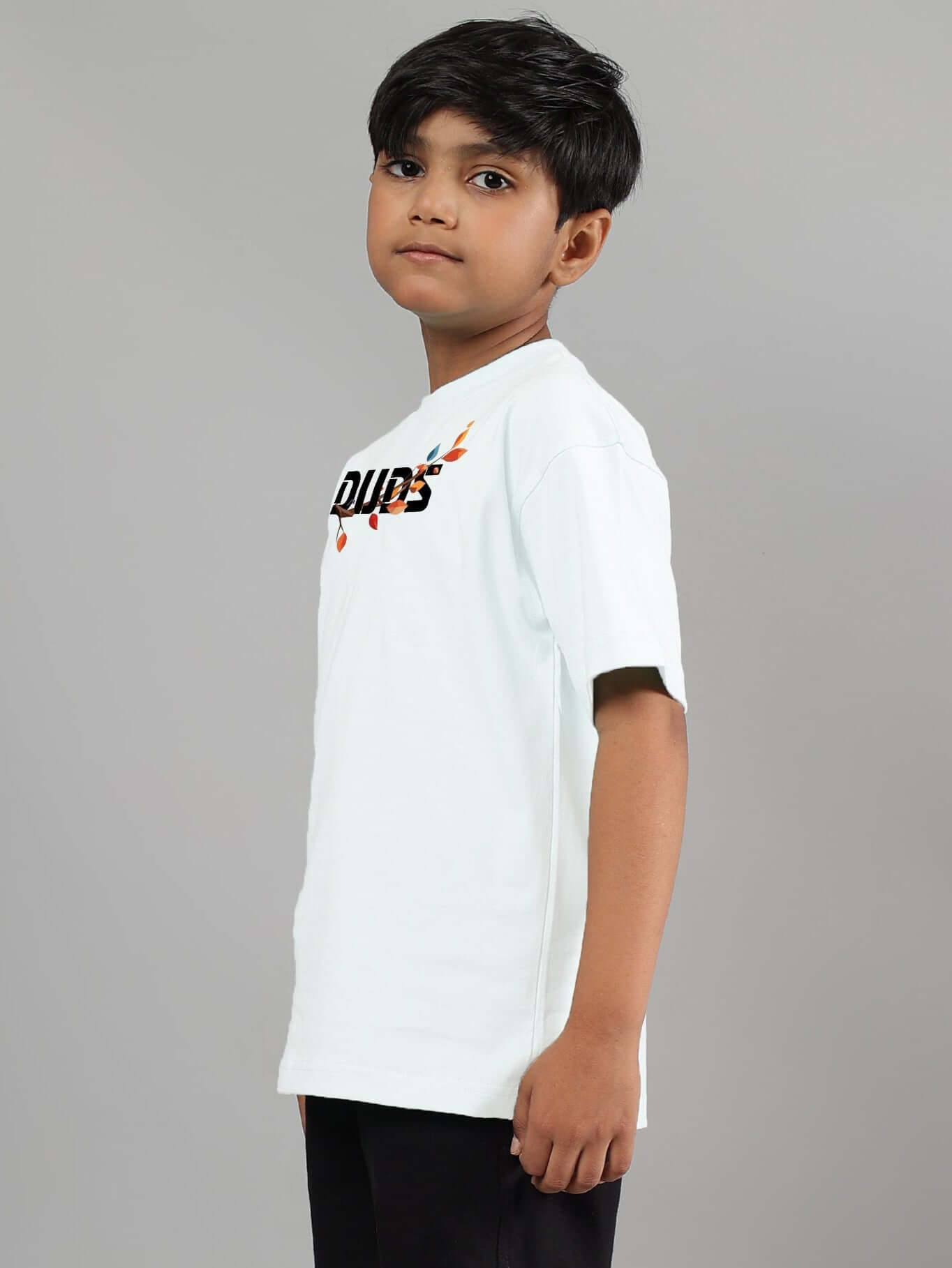 Boy wearing white Hedwig T-shirt for kids by DUDS, side view, showcasing logo design, perfect for boys and girls.