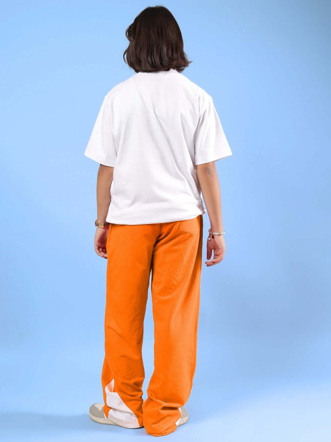 HELLO SPRING CO-ORD FOR BOYS & GIRLS WHITE-ORANGE, back view of a child wearing orange pants and a white T-shirt against a blue background.