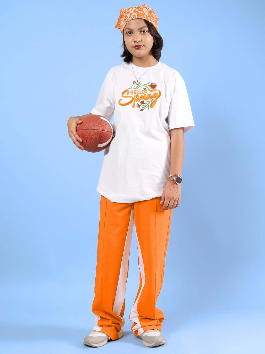 Child wearing Hello Spring Co-Ord for Boys & Girls White-Orange, holding a ball, against blue background. Ideal made-to-order outfit for kids.