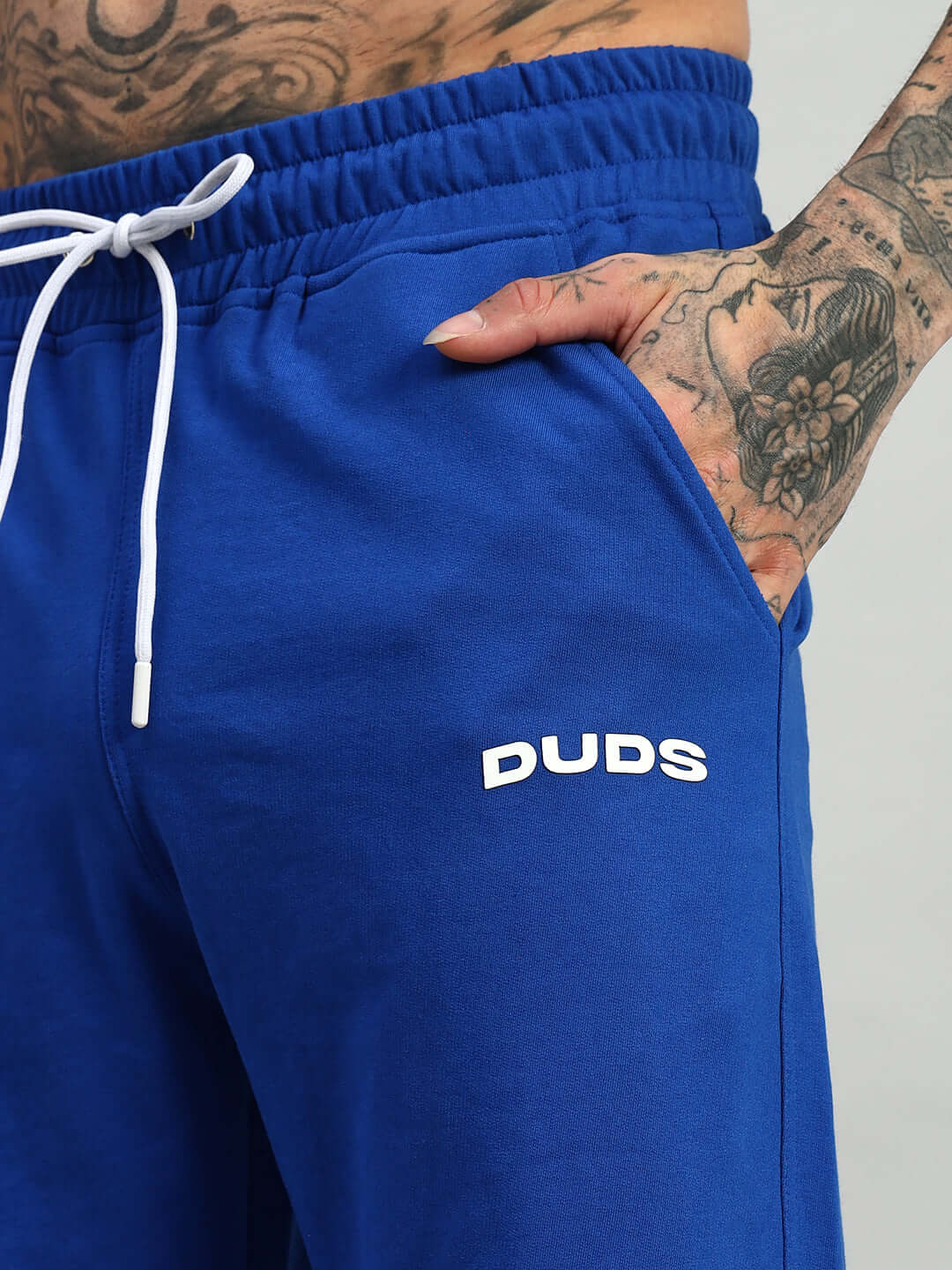 Close-up of Hershey Side Slit Joggers in royal blue by DUDS, featuring a white drawstring and side pocket detail.