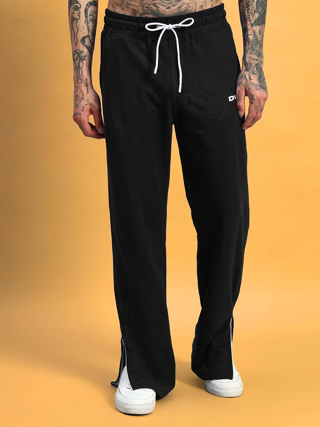 Black Hershey side slit joggers by DUDS with custom fit option, featuring white drawstring and casual style against a yellow background.