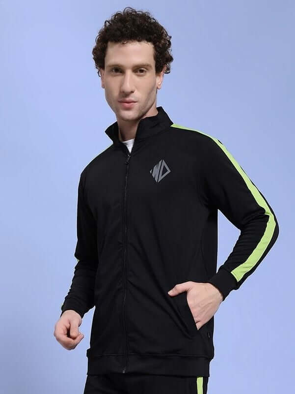 Man wearing HIGH PERFORMANCE JACKET IN BLACK with stylish design and green accents, perfect for athletes and urban explorers.