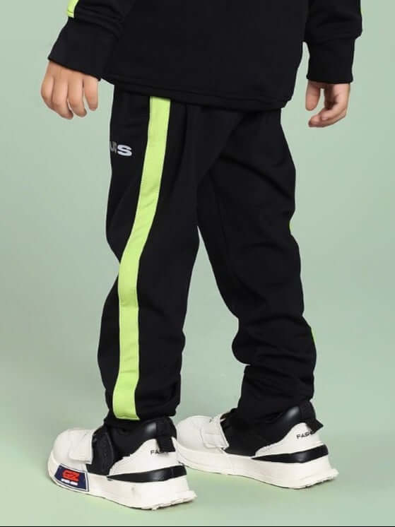 Child wearing the HIGH PERFORMANCE JOGGER FOR BOYS AND GIRLS BLACK in a sporty setting.
