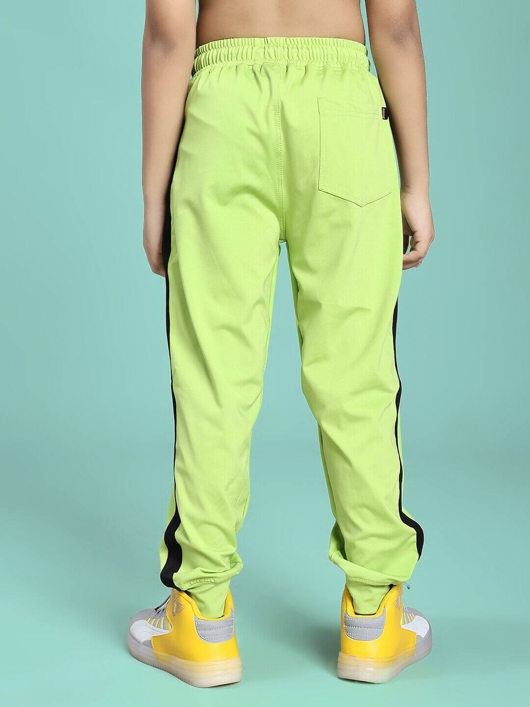 Child wearing HIGH PERFORMANCE JOGGER FOR BOYS AND GIRLS NEON GREEN, showcasing back view and design details.