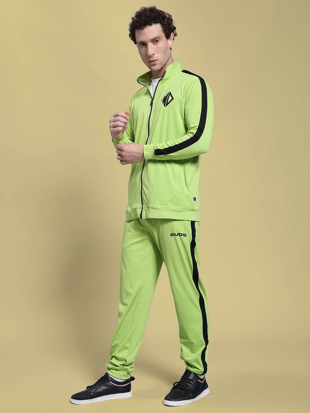 Man wearing HIGH PERFORMANCE CO-ORD SET NEON GREEN with zip-up hoodie and joggers, showcasing athletic look on neutral background.