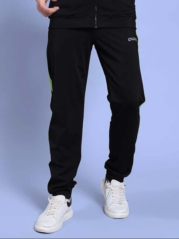 Man wearing HIGH PERFORMANCE RELAXED FIT JOGGER BLACK with white sneakers, showcasing comfort and style.