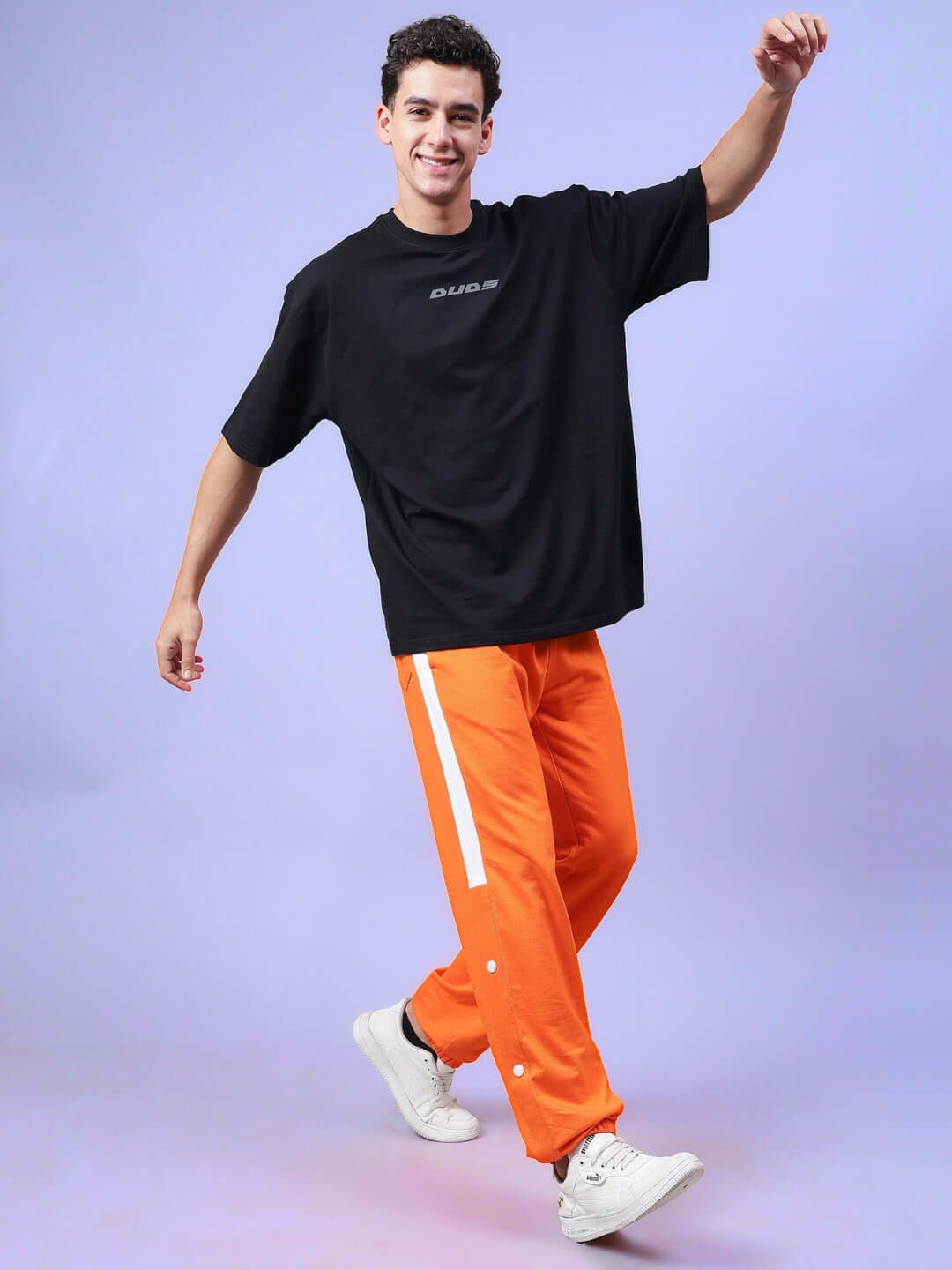 Model wearing High Point Contrast Joggers in Orange-White with casual black tee and white sneakers, showcasing comfortable fit.