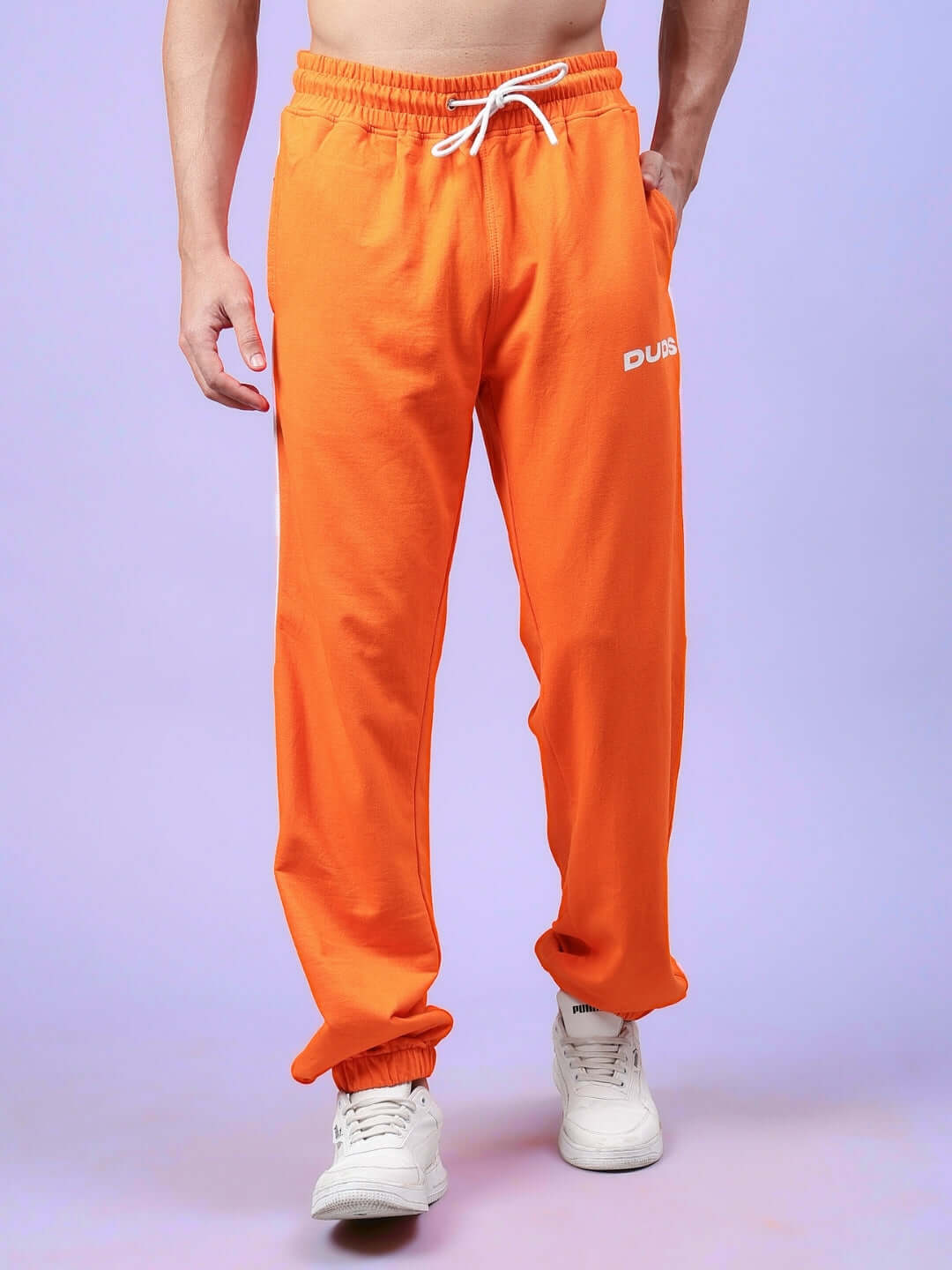 Person wearing DUDS orange-white contrast joggers with adjustable drawstring and elastic cuffs.
