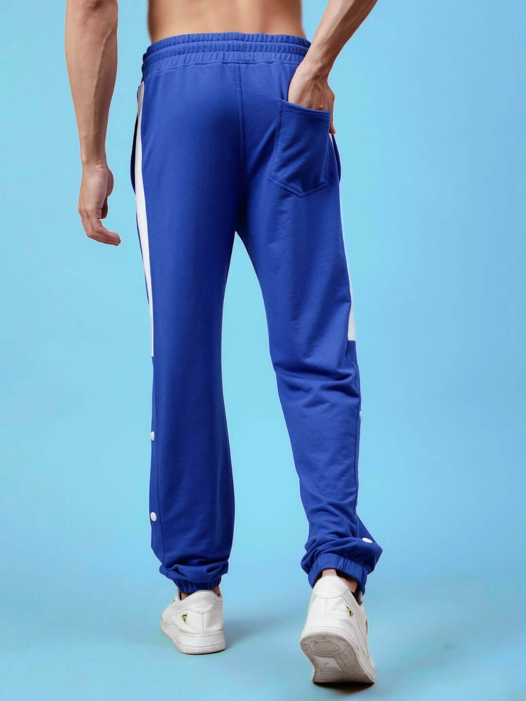 Rear view of High Point Contrast Joggers in royal blue and white, showing elastic waist and side pocket, modeled on a blue background.