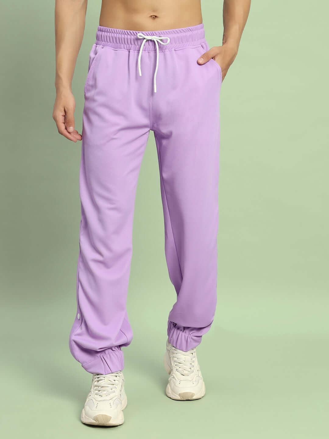 Man wearing lavender hip hop joggers with white sneakers, showcasing relaxed fit and elastic waistband, made by DUDS.