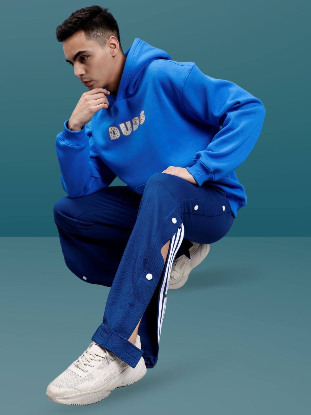 Man wearing marine blue hip hop joggers with customizable fit, styled with a DUDS hoodie, highlighting casual fashion by DUDS.