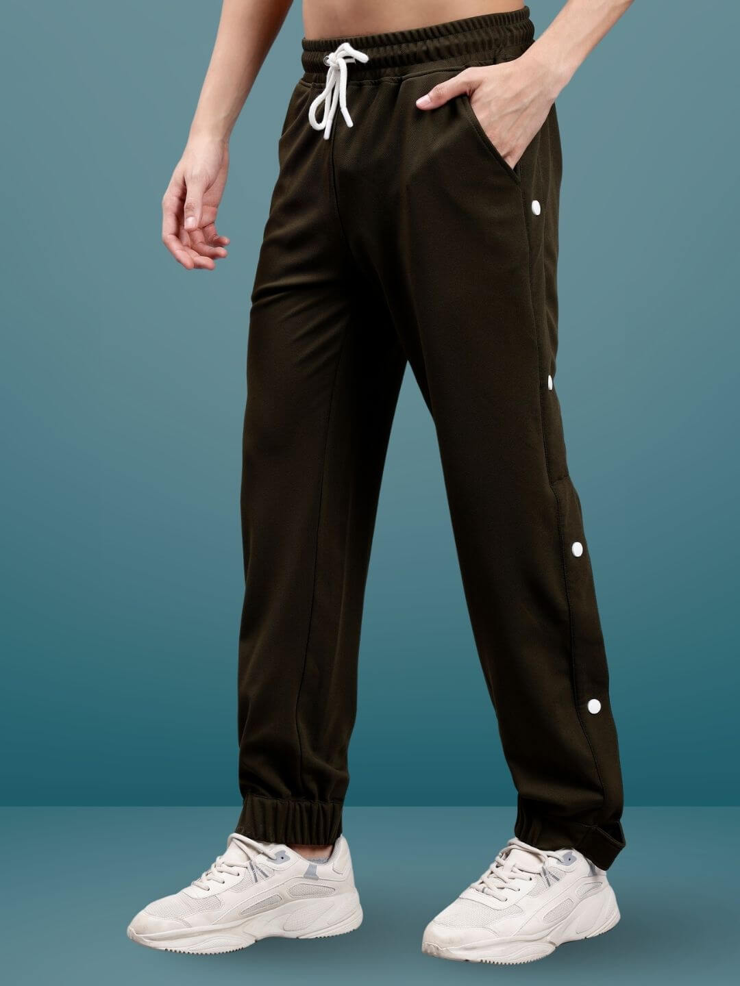 Model wearing military green hip hop joggers with white sneakers against a blue background, showcasing custom fit option.