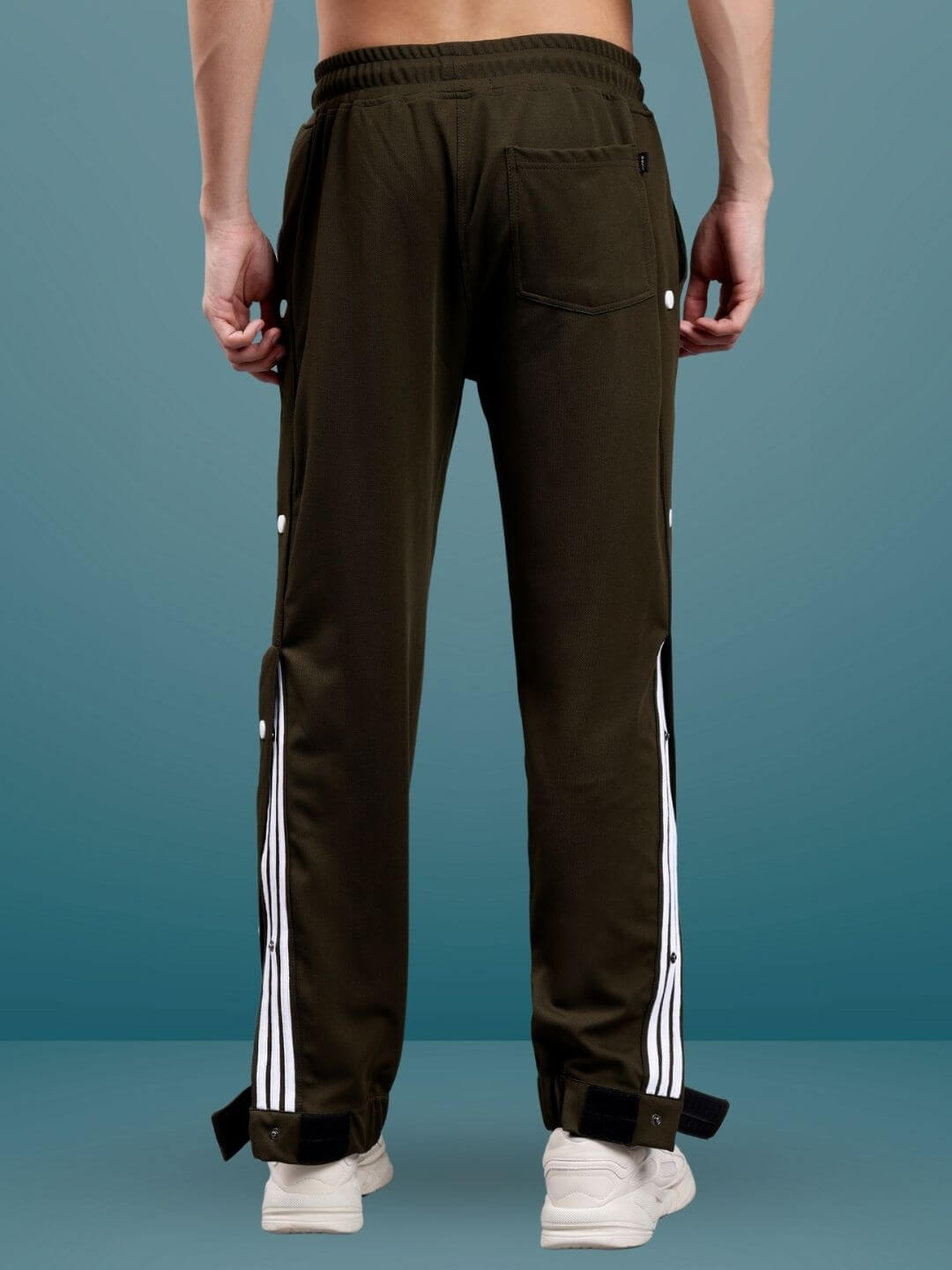 Back view of military green hip hop joggers with white stripe detailing and adjustable hems, modeled by a person standing.