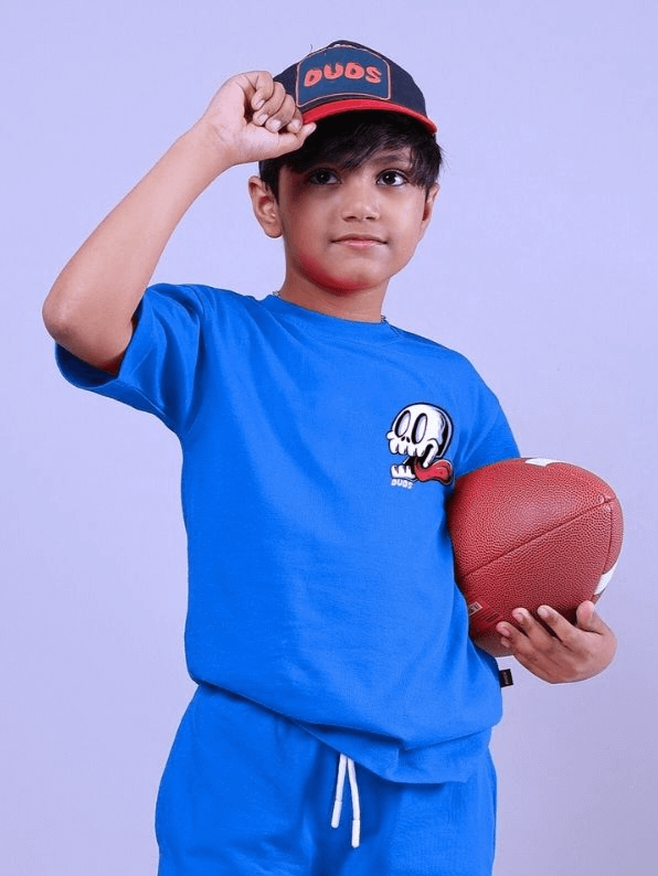 Child wearing HOLIDAY TIME RIDER PRINT T-SHIRT FOR BOYS AND GIRLS BLUE holding a football