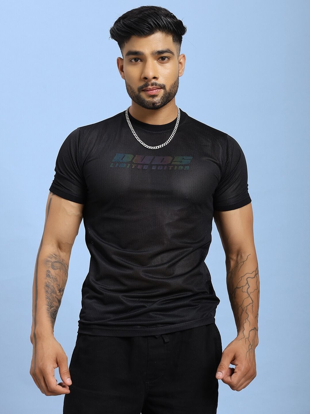 Model wearing HOLO BLACK MESH REGULAR FIT T-SHIRT BLACK showcasing mesh panels and relaxed fit on blue background