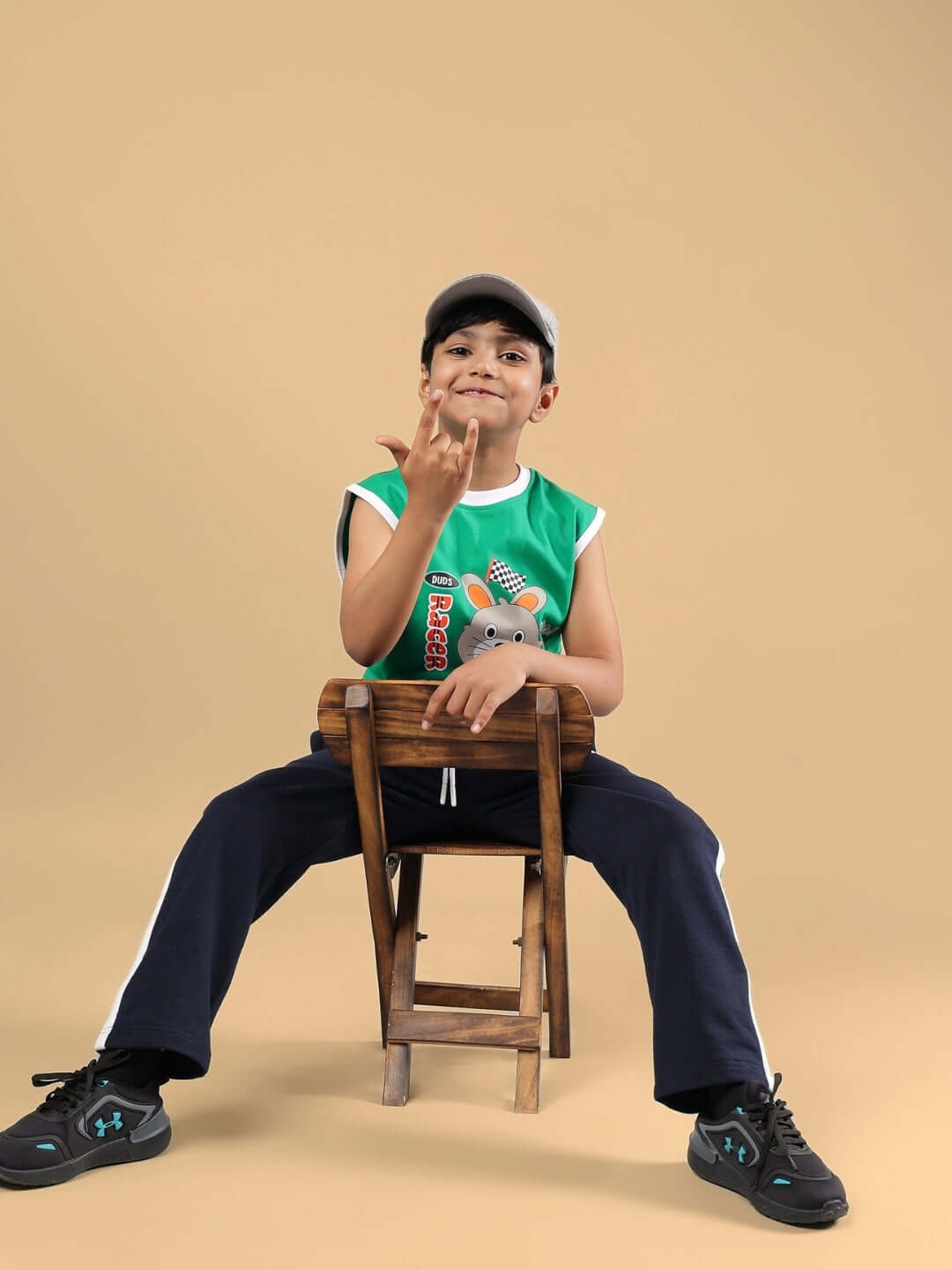 Child wearing HOOFER JOGGER FOR BOYS & GIRLS NAVY BLUE-GREEN sitting on a wooden chair.