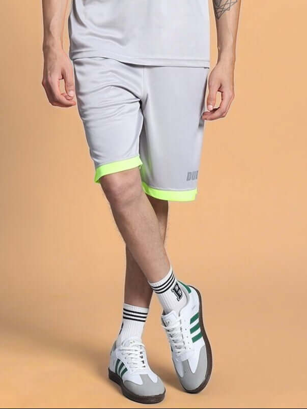 Model wearing HOOKUP REGULAR FIT SHORTS GREY with neon accents, showing casual style and comfort.