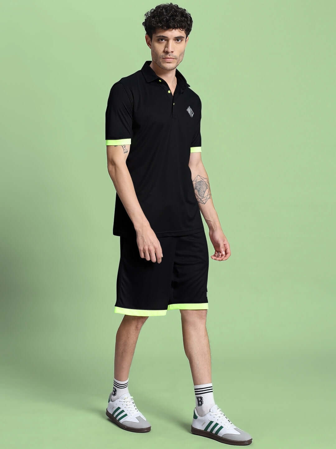 Person wearing HOOKUP REFLECTOR SUMMER CO-ORD SET BLACK against green background, showcasing sleek style and comfort.