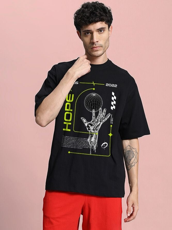 Man wearing HOPE PRINTED OVERSIZED T-SHIRT BLACK with graphic design, showcasing bold minimalistic style.