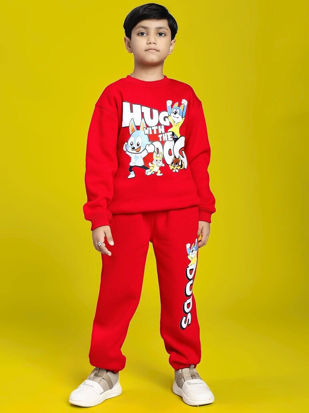 Child wearing HUG WITH THE DOG FLEECE CO-ORD FOR BOYS AND GIRLS RED, featuring a fun dog graphic and bold color, against yellow background.