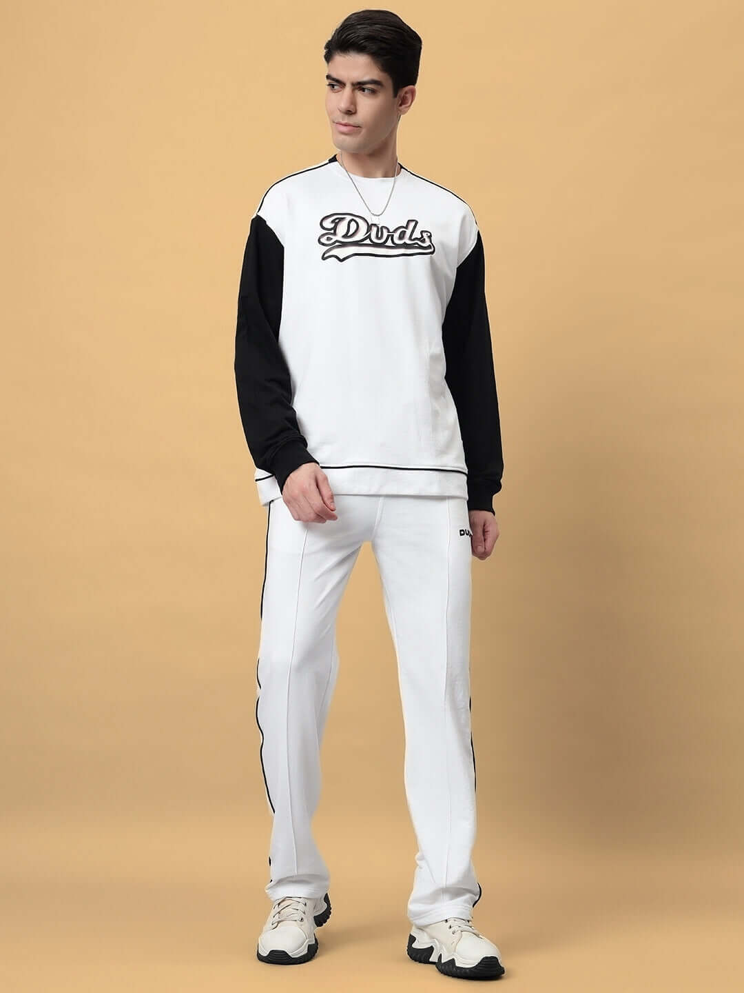 Model wearing HUNK OVERSIZED CO-ORD SET WHITE with black and white design, showcasing streetwear style with relaxed-fit pants and oversized shirt.
