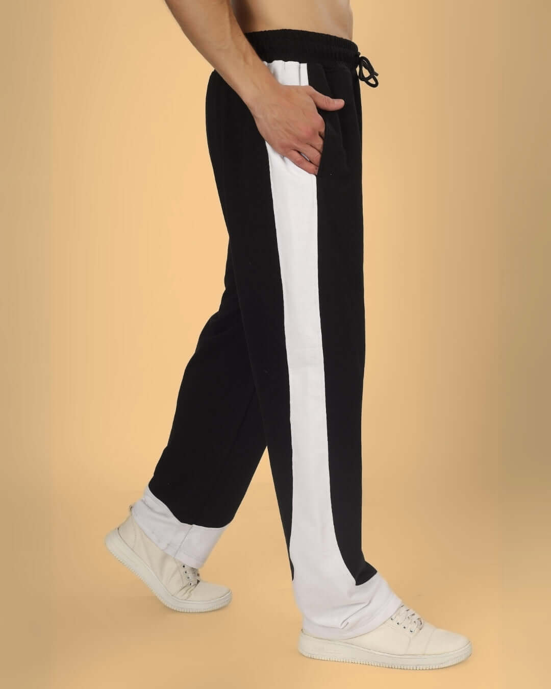 Model wearing black and white HURTLE BAGGY JOGGERS with white sneakers, showcasing side profile and design details.