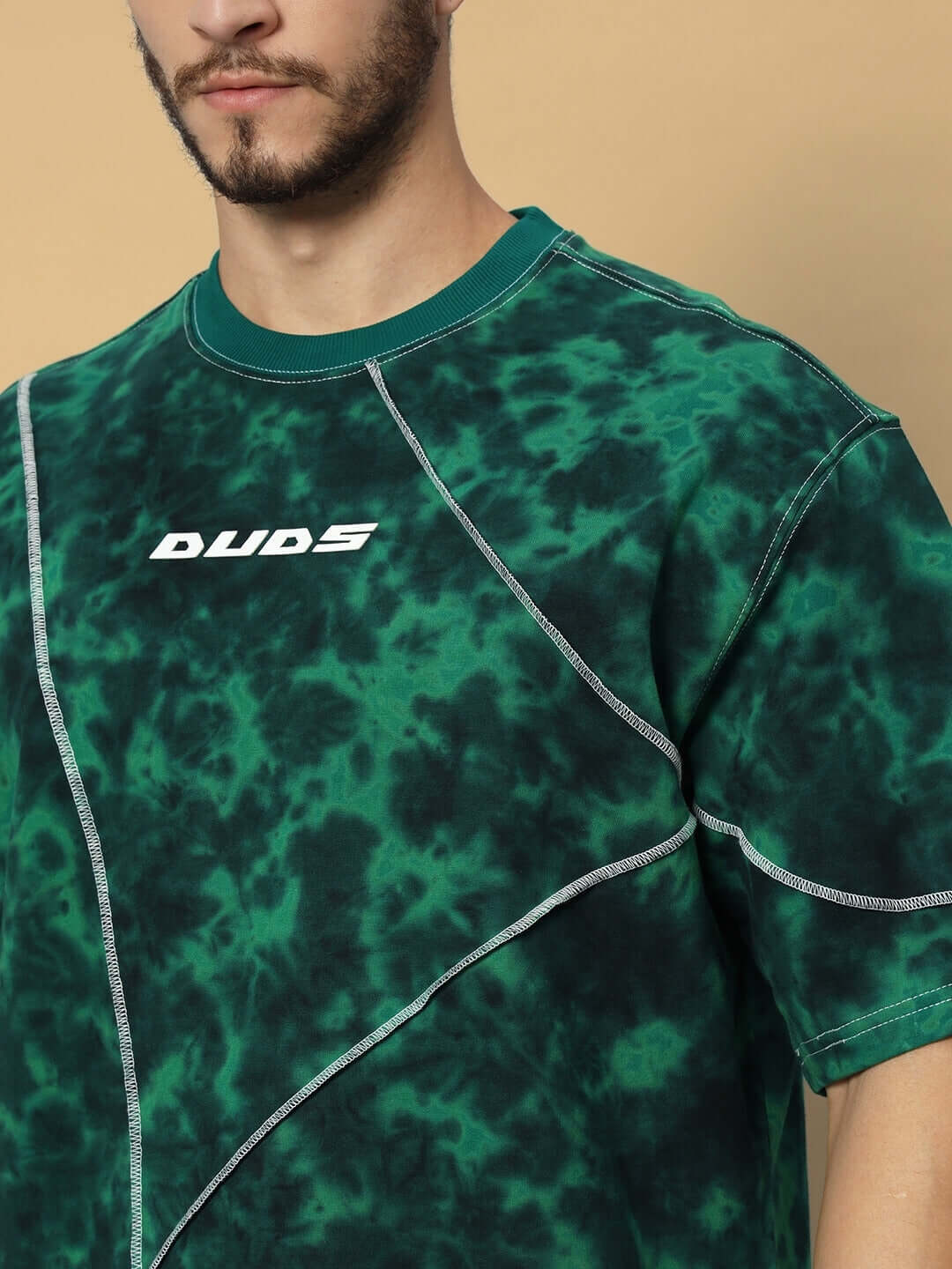 Model wearing green oversized tie-dye T-shirt with white logo, made from premium cotton blend, designed by Color By Colours. Ideal for casual wear.