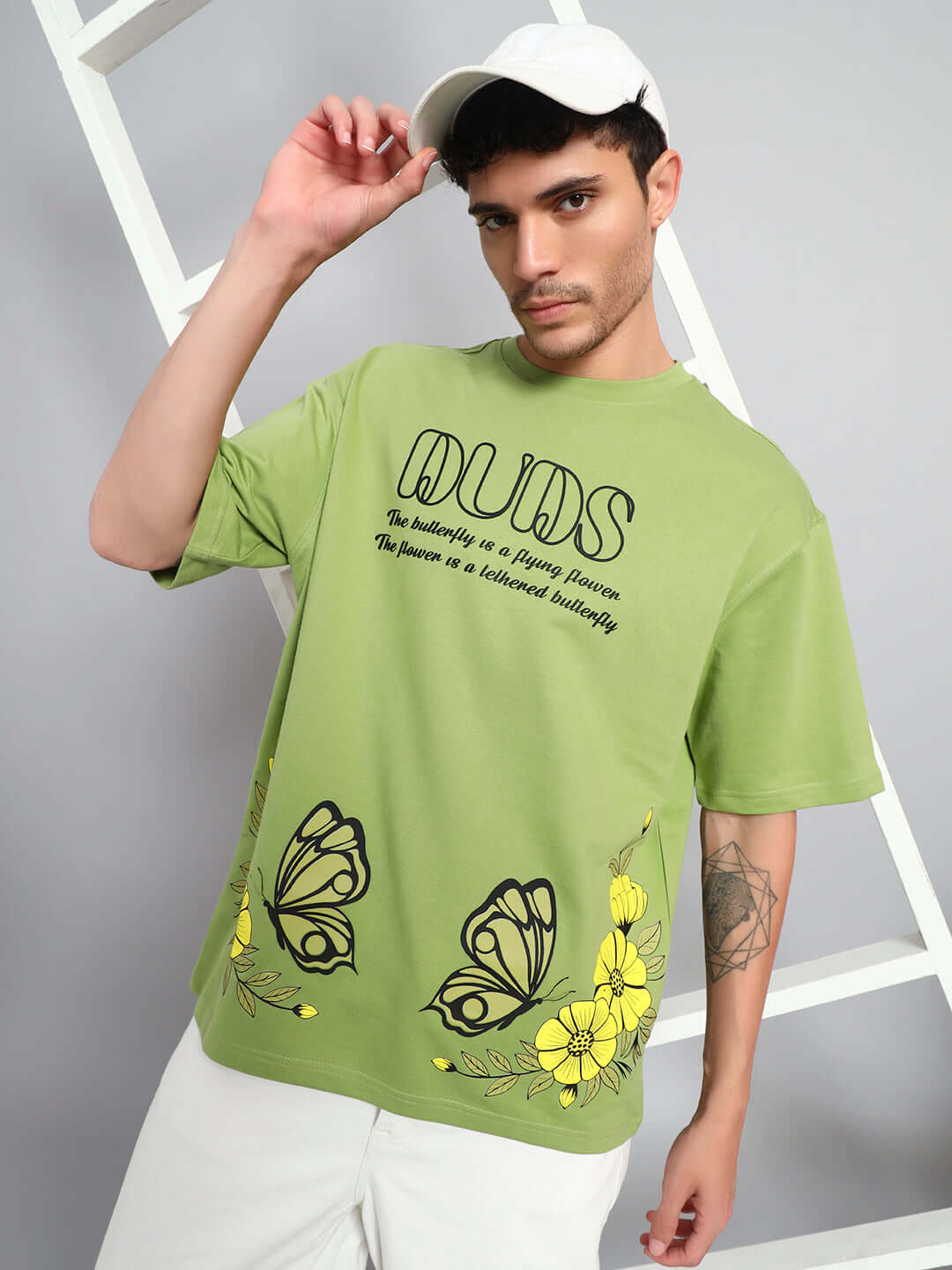 Man wearing IKON BUTTERFLY T-SHIRT GREEN MEN with striking butterfly graphic and bold streetwear design.