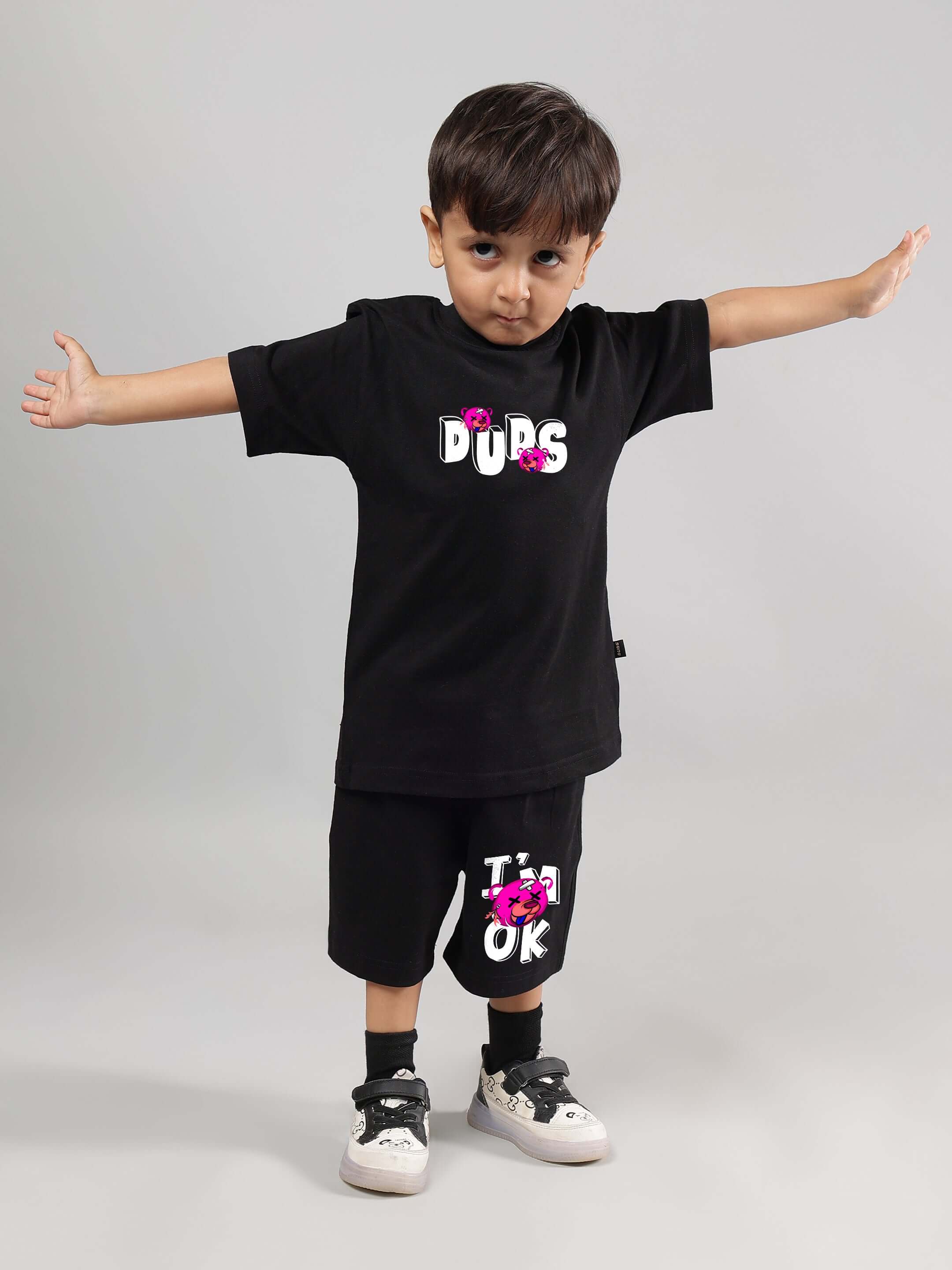 Child wearing black I'M OK co-ord by DUDS, featuring playful graphics, suitable for boys and girls, customizable fit available.