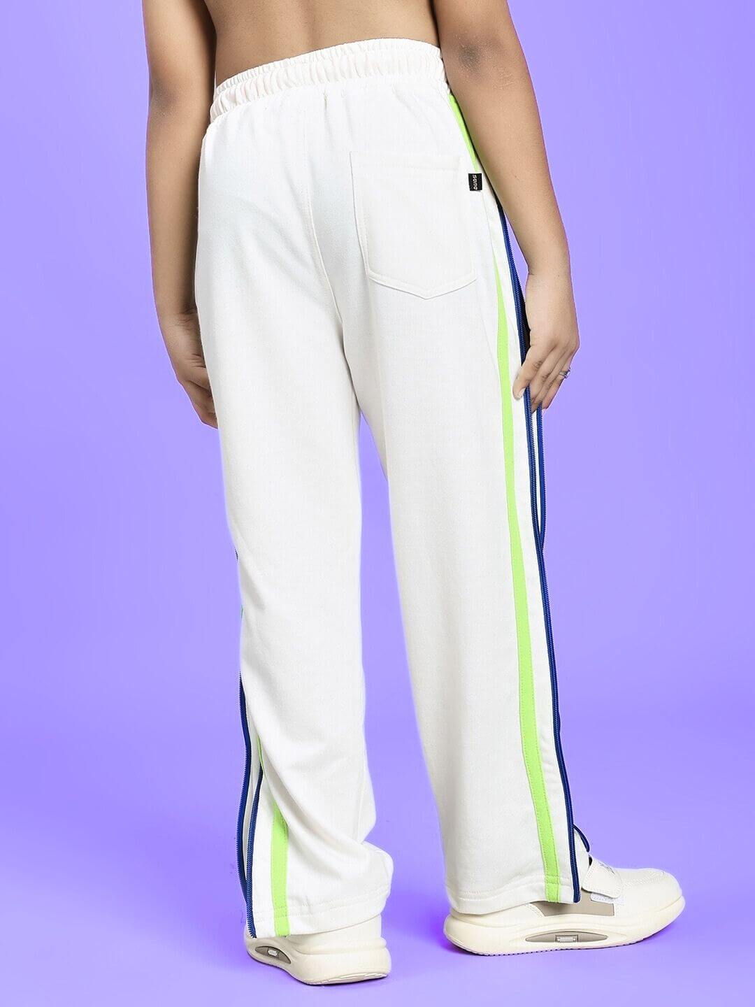 Child wearing IMPERIAL SIDE ZIPPER JOGGER FOR BOYS AND GIRLS OFF WHITE with side stripes on a purple background