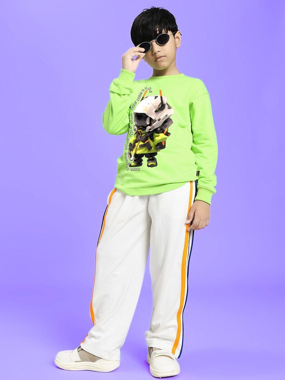 Child wearing IMPERIAL SIDE ZIPPER JOGGER FOR BOYS AND GIRLS OFF WHITE with a bright green top on a purple background.