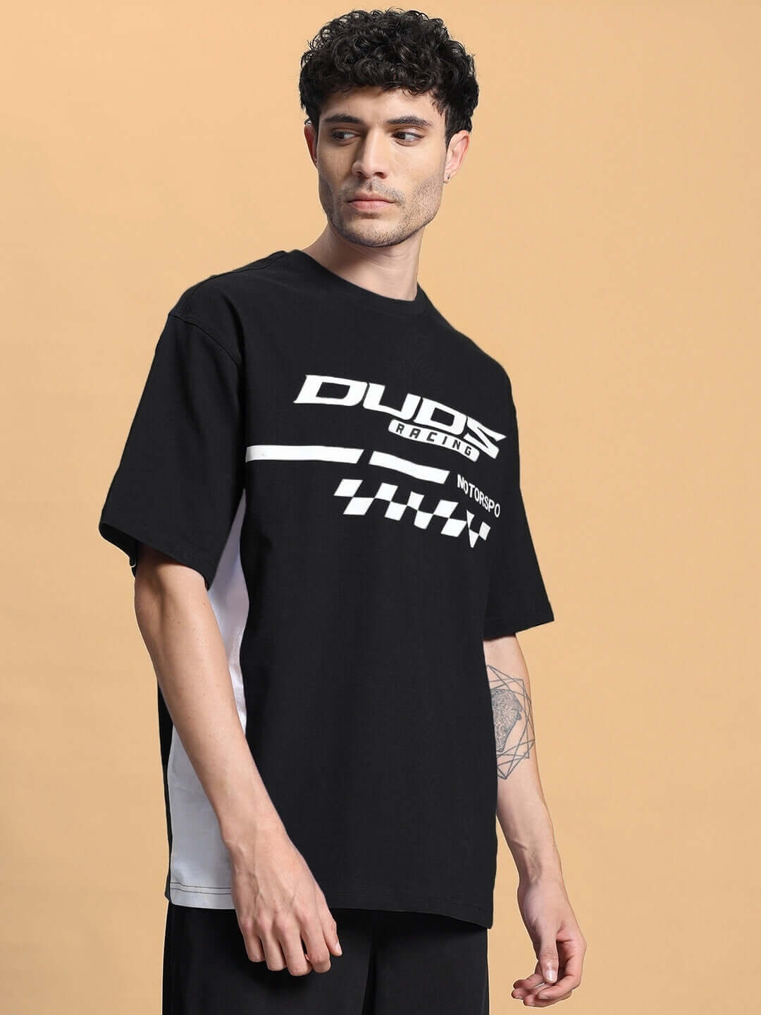 Model wearing INDY OVER-SIZED CLASSIC T-SHIRT BLACK with graphic design, front view.