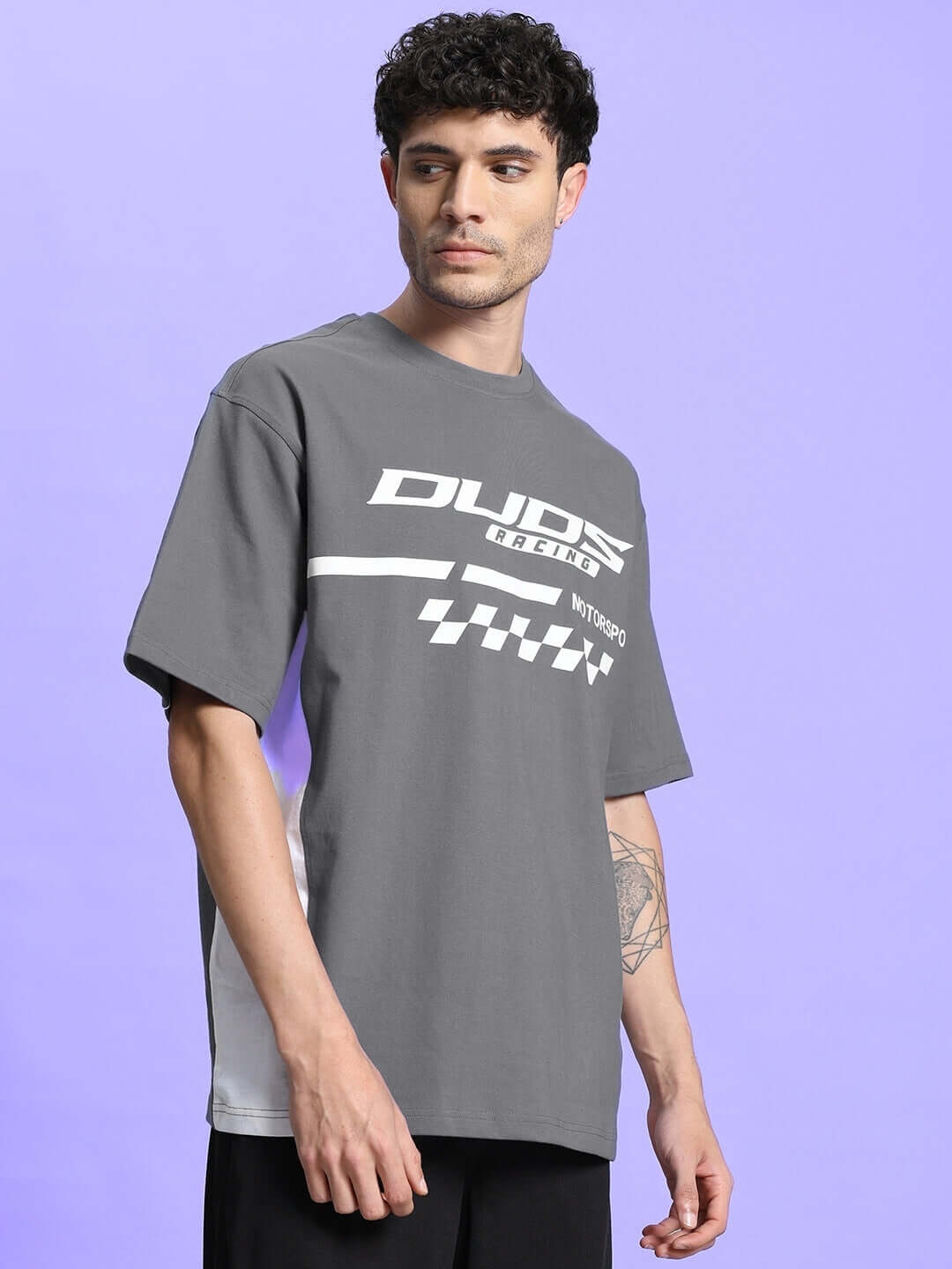 Man wearing INDY OVER-SIZED CLASSIC T-SHIRT GREY showcasing stylish graphic design and relaxed fit.